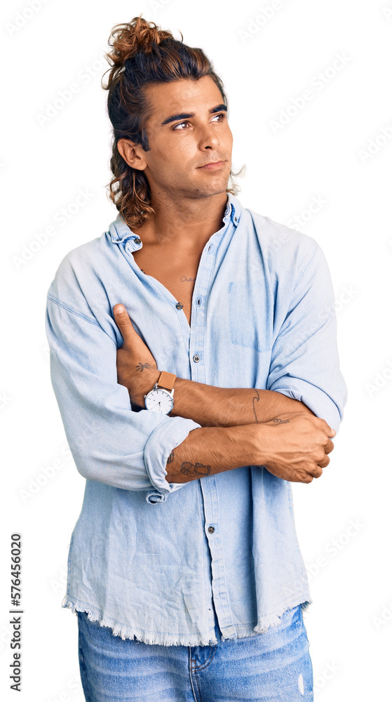 Young hispanic man wearing summer style looking to the side with arms crossed convinced and confident Young hispanic man wearing summer style looking to the side with arms crossed convinced and confident