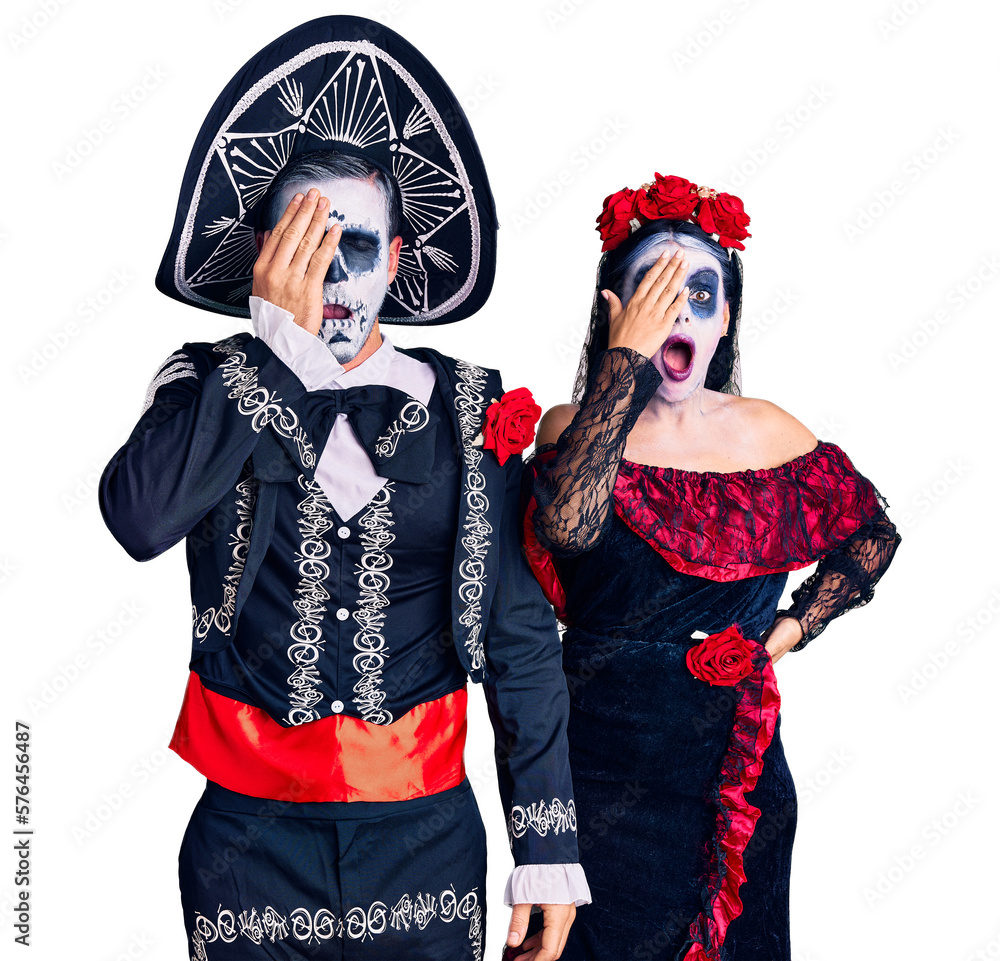 Young couple wearing mexican day of the dead costume over background yawning tired covering half face, eye and mouth with hand. face hurts in pain.