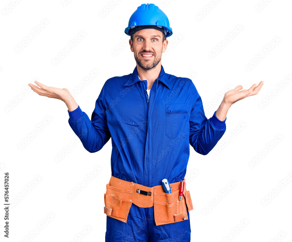 Young handsome man wearing worker uniform and hardhat smiling showing both hands open palms, presenting and advertising comparison and balance