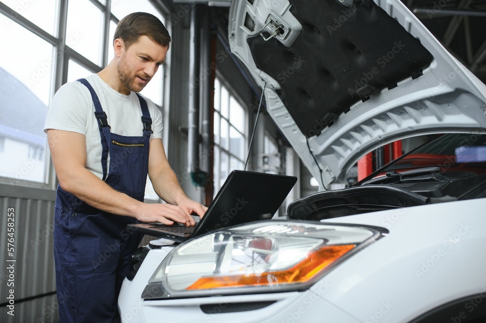 car mechanic using a computer laptop to diagnosing and checking up on car engines parts for fixing and repair car mechanic using a computer laptop to diagnosing and checking up on car engines parts for fixing and repair