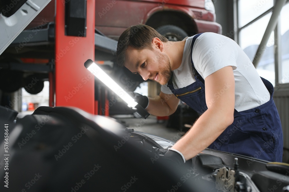 Portrait of a smiling fixing a car engine in his garage Portrait of a smiling fixing a car engine in his garage