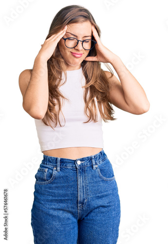 Beautiful caucasian young woman wearing casual clothes and glasses with hand on head for pain in head because stress. suffering migraine.