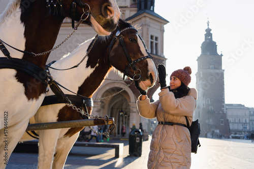 Tourists and Horses in Main Market Square in Krakow, Poland