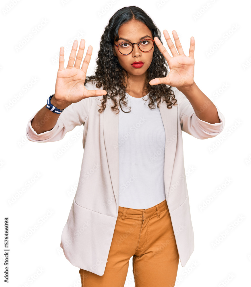 Young african american girl wearing business clothes doing frame using hands palms and fingers, camera perspective Young african american girl wearing business clothes doing frame using hands palms and fingers, camera perspective