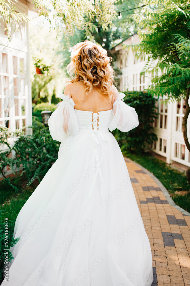 rear view. the bride walks through the garden. rear view. the bride walks through the garden.