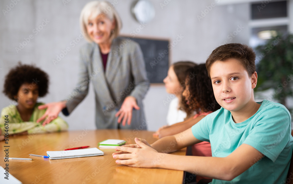 While working in classroom, teacher explains to children new information on subject