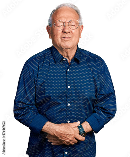 Senior man with grey hair wearing casual shirt and glasses with hand on stomach because indigestion, painful illness feeling unwell. ache concept.