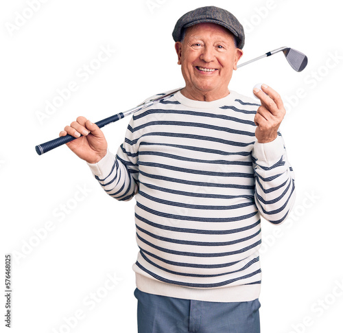 Senior handsome grey-haired man holding golf club and ball looking positive and happy standing and smiling with a confident smile showing teeth