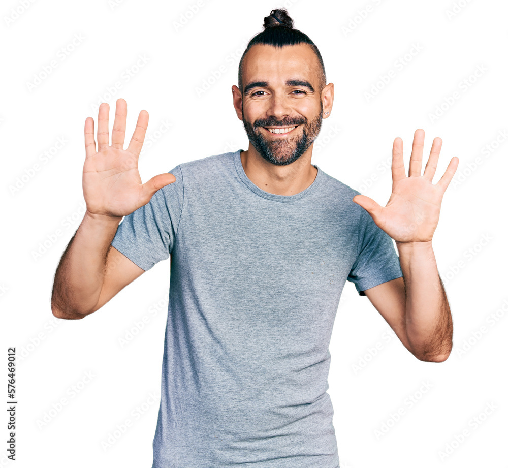 Hispanic man with ponytail wearing casual grey t shirt showing and pointing up with fingers number ten while smiling confident and happy. Hispanic man with ponytail wearing casual grey t shirt showing and pointing up with fingers number ten while smiling confident and happy.