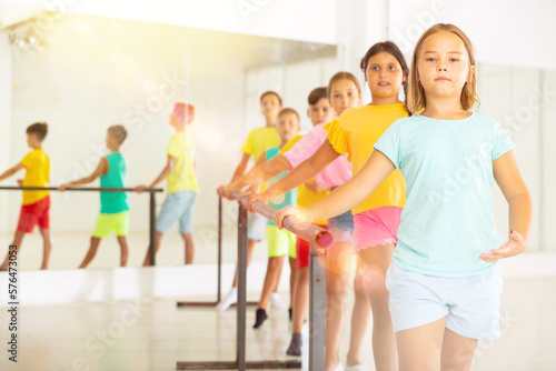 Children exercising ballet moves during their group training.