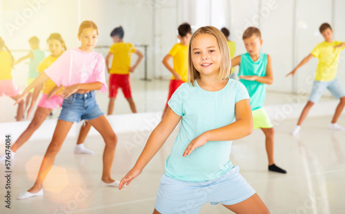 Group of kids training modern dance moves together in studio.