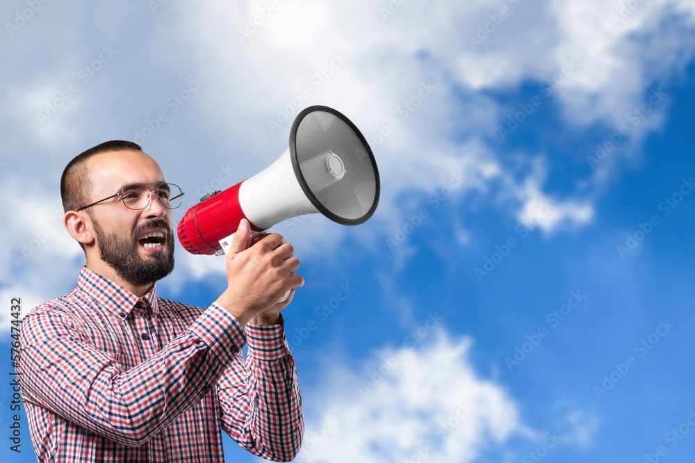 Happy young man posing, screaming on megaphone. Happy young man posing, screaming on megaphone.