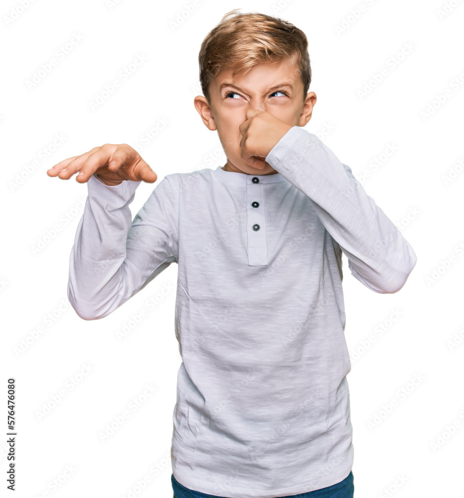 Little caucasian boy kid wearing casual clothes smelling something ...