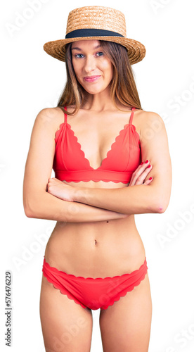 Beautiful brunette young woman wearing bikini happy face smiling with crossed arms looking at the camera. positive person.