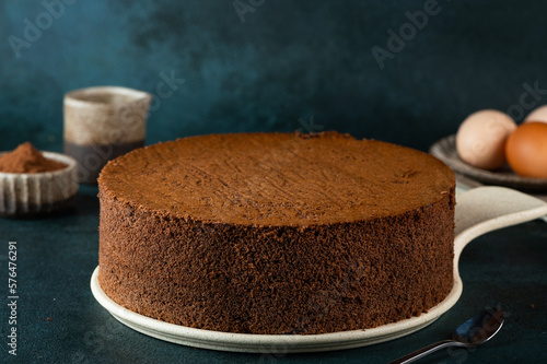 Homemade round chocolate sponge cake or chiffon cake. Sponge cake ingredients: eggs, flour and cocoa. Chocolate biscuit