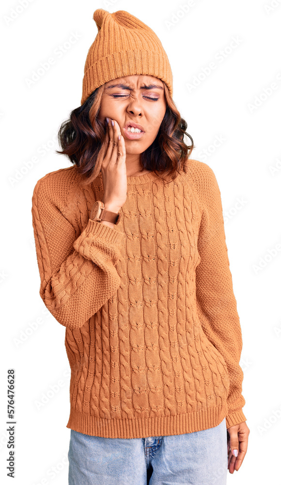 Young beautiful mixed race woman wearing wool sweater and winter hat touching mouth with hand with painful expression because of toothache or dental illness on teeth. dentist Young beautiful mixed race woman wearing wool sweater and winter hat touching mouth with hand with painful expression because of toothache or dental illness on teeth. dentist