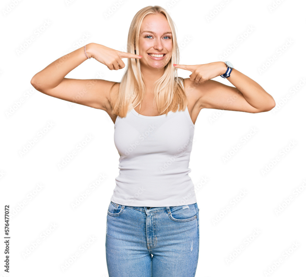 Young blonde girl wearing casual style with sleeveless shirt smiling cheerful showing and pointing with fingers teeth and mouth. dental health concept. Young blonde girl wearing casual style with sleeveless shirt smiling cheerful showing and pointing with fingers teeth and mouth. dental health concept.