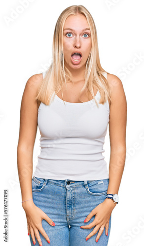 Young blonde girl wearing casual style with sleeveless shirt afraid and shocked with surprise and amazed expression, fear and excited face. © Krakenimages.com