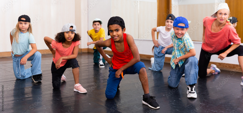 Positive girls and boys training hip hop in dance studio, dance classes for kids