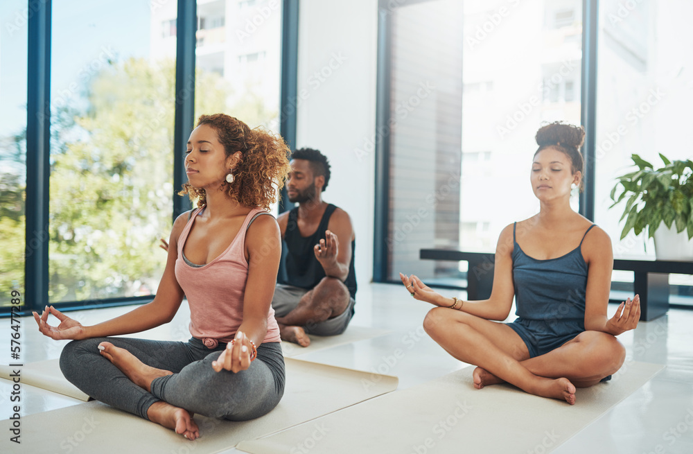 Coming together for a common goal in fitness. Shot of a group of people doing yoga. Coming together for a common goal in fitness. Shot of a group of people doing yoga.