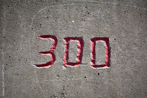 the number 300 in red on a concrete wall