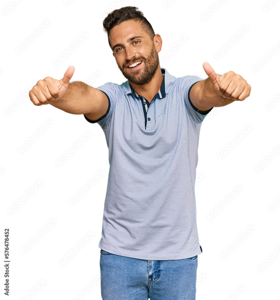 Handsome man with beard wearing casual clothes approving doing positive gesture with hand, thumbs up smiling and happy for success. winner gesture. Handsome man with beard wearing casual clothes approving doing positive gesture with hand, thumbs up smiling and happy for success. winner gesture.