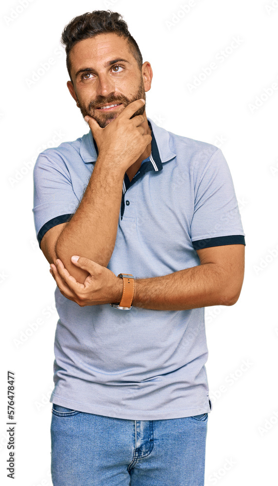 Handsome man with beard wearing casual clothes with hand on chin thinking about question, pensive expression. smiling and thoughtful face. doubt concept. Handsome man with beard wearing casual clothes with hand on chin thinking about question, pensive expression. smiling and thoughtful face. doubt concept.
