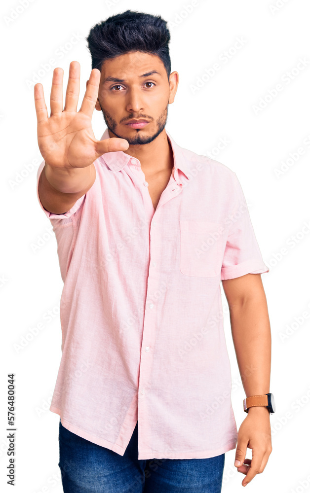 Handsome latin american young man wearing casual summer shirt doing stop sing with palm of the hand. warning expression with negative and serious gesture on the face. Handsome latin american young man wearing casual summer shirt doing stop sing with palm of the hand. warning expression with negative and serious gesture on the face.