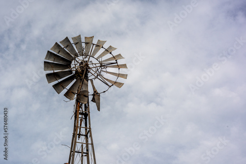 A broken windmill for water extraction with cloudy blue sky as background