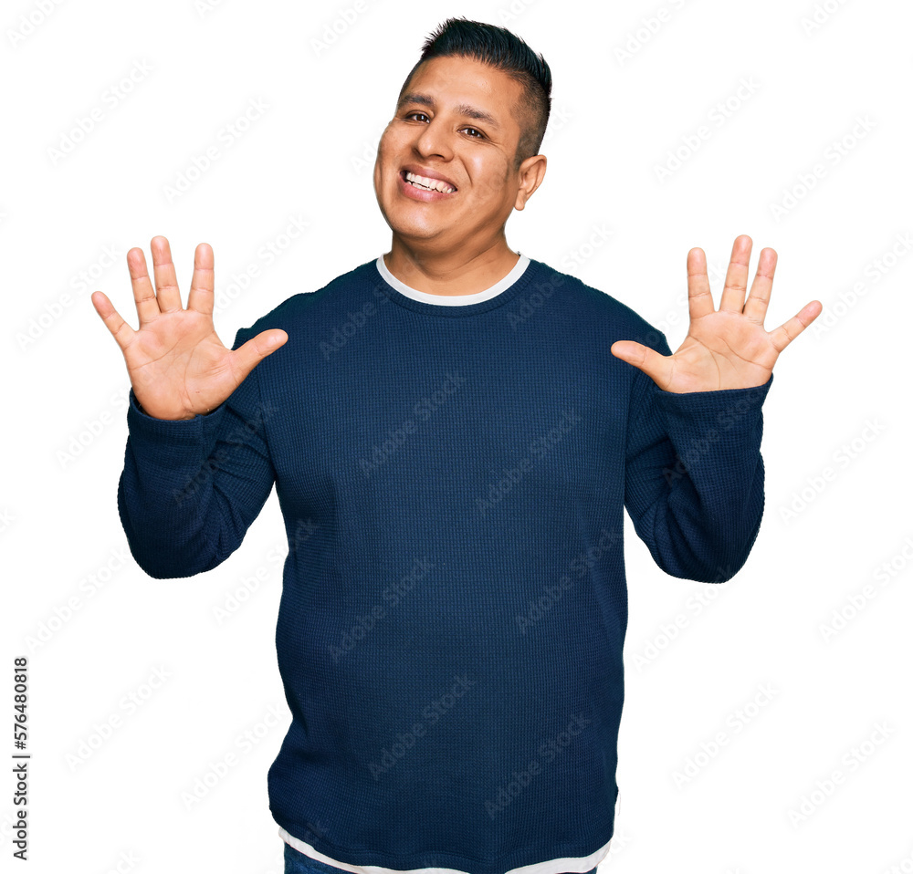 Young latin man wearing casual clothes showing and pointing up with fingers number ten while smiling confident and happy. Young latin man wearing casual clothes showing and pointing up with fingers number ten while smiling confident and happy.