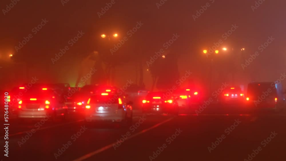 In a traffic jam in the city on a foggy evening, a policeman drives past cars on a unicycle In a traffic jam in the city on a foggy evening, a policeman drives past cars on a unicycle