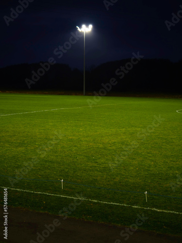 Training ground with grass illuminated by modern powerful LED lights. Efficient modern technology. Nobody.