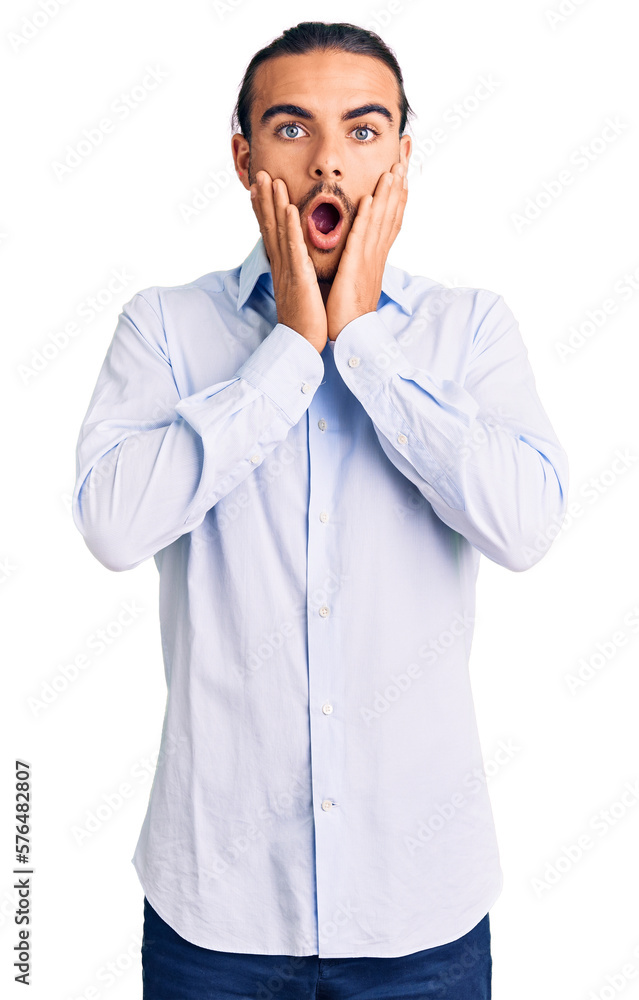 Young handsome man wearing business clothes afraid and shocked, surprise and amazed expression with hands on face Young handsome man wearing business clothes afraid and shocked, surprise and amazed expression with hands on face