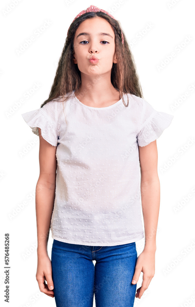 Fototapeta premium Cute hispanic child girl wearing casual white tshirt looking at the camera blowing a kiss on air being lovely and sexy. love expression.