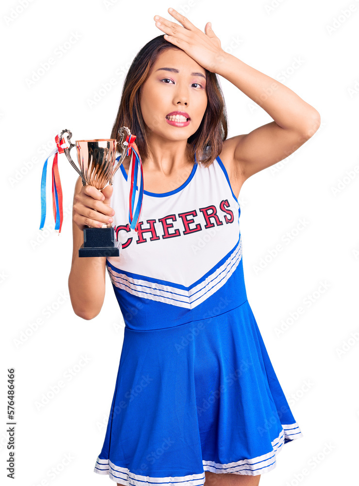 Youn beautiful asian girl wearing cheerleader uniform holding champion trophy stressed and frustrated with hand on head, surprised and angry face Youn beautiful asian girl wearing cheerleader uniform holding champion trophy stressed and frustrated with hand on head, surprised and angry face