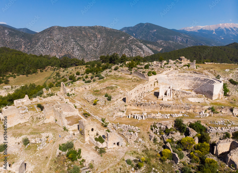 View from drone of ruins of Roman amphitheater at archaeological site of ancient city of Rhodiapolis and picturesque mountain surroundings on spring day, Kumluca, Turkey