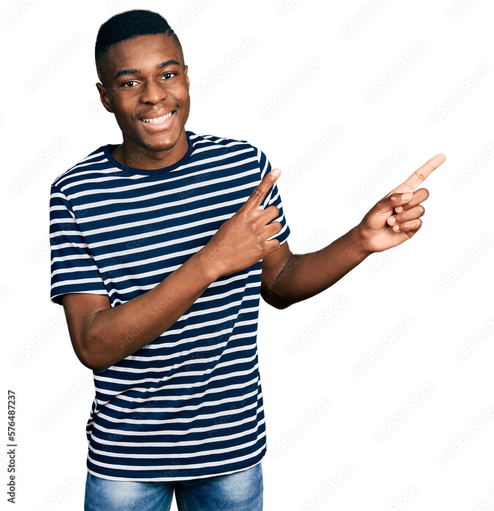 Young african american man wearing casual striped t shirt smiling and looking at the camera pointing with two hands and fingers to the side. Young african american man wearing casual striped t shirt smiling and looking at the camera pointing with two hands and fingers to the side.