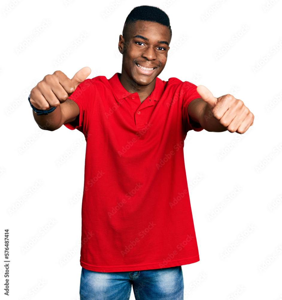 Young african american man wearing casual red t shirt approving doing positive gesture with hand, thumbs up smiling and happy for success. winner gesture. Young african american man wearing casual red t shirt approving doing positive gesture with hand, thumbs up smiling and happy for success. winner gesture.