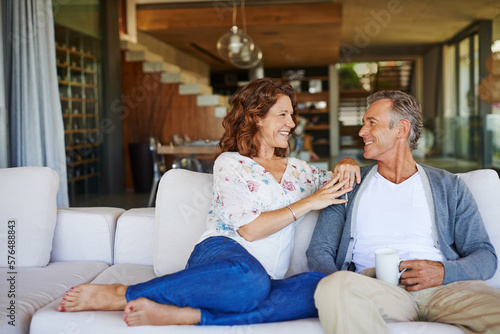 And then I said.... A happy mature couple enjoying a cup of coffee together on the sofa at home.