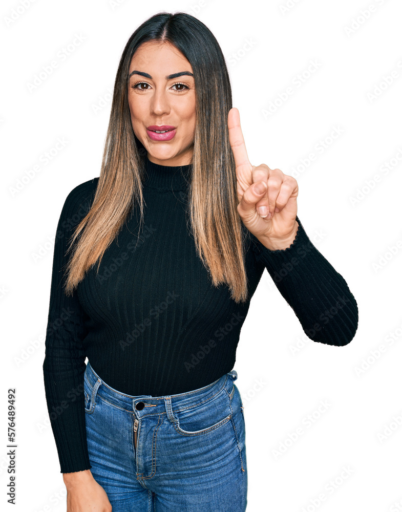 Young hispanic woman wearing casual clothes showing and pointing up with finger number one while smiling confident and happy. Young hispanic woman wearing casual clothes showing and pointing up with finger number one while smiling confident and happy.