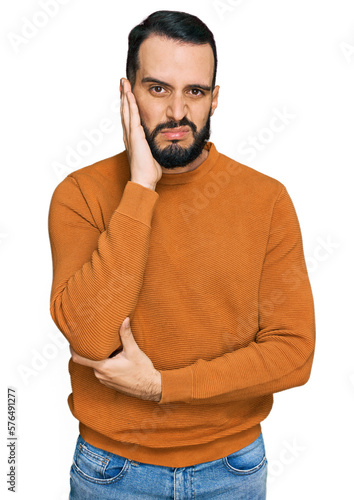 Young man with beard wearing casual winter sweater thinking looking tired and bored with depression problems with crossed arms.