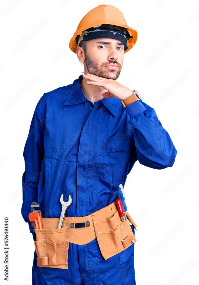 Young hispanic man wearing worker uniform cutting throat with hand as knife, threaten aggression with furious violence