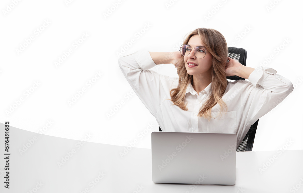 Young smiling business woman or office worker sitting behind a desk with a laptop. Relaxed business woman leaning back in chair and hands behind head isolated on white background. Satisfied worker Young smiling business woman or office worker sitting behind a desk with a laptop. Relaxed business woman leaning back in chair and hands behind head isolated on white background. Satisfied worker