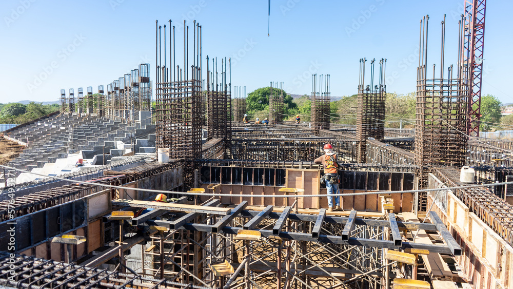 A group of Latino workers strives to erect a new stadium in an latin American city. Their work contributes to the economic and social development of the region, but also faces challenges and risks