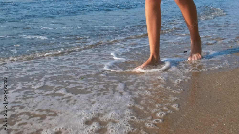 Barefoot teen in sea foam. A nice barefoot walking along sea foam in summer. Barefoot teen in sea foam. A nice barefoot walking along sea foam in summer.