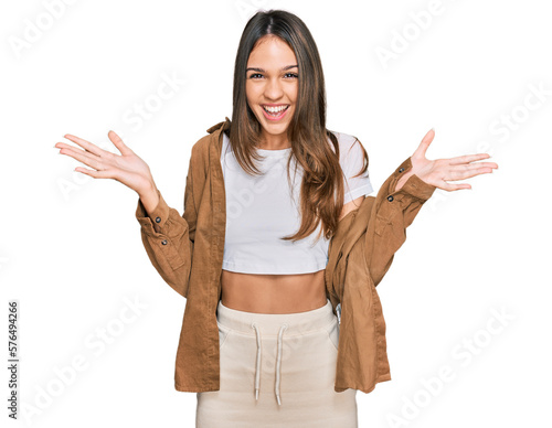 Young brunette woman wearing casual clothes celebrating victory with happy smile and winner expression with raised hands photo