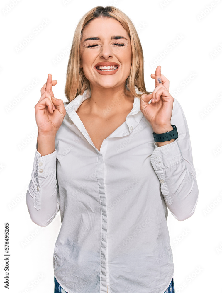 Young caucasian woman wearing casual clothes gesturing finger crossed smiling with hope and eyes closed. luck and superstitious concept. Young caucasian woman wearing casual clothes gesturing finger crossed smiling with hope and eyes closed. luck and superstitious concept.
