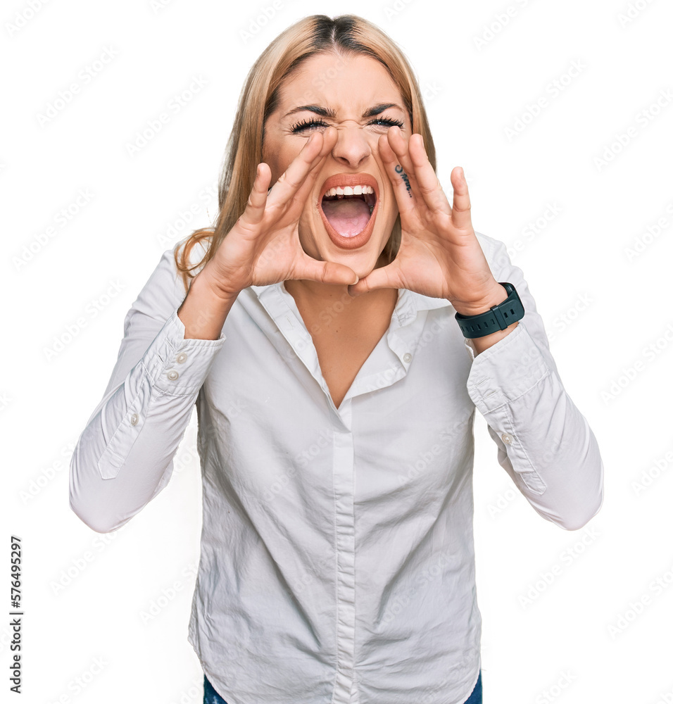 Young caucasian woman wearing casual clothes shouting angry out loud with hands over mouth Young caucasian woman wearing casual clothes shouting angry out loud with hands over mouth