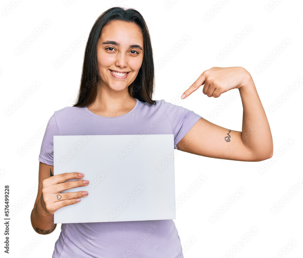 Young hispanic woman holding blank empty banner pointing finger to one self smiling happy and proud Young hispanic woman holding blank empty banner pointing finger to one self smiling happy and proud