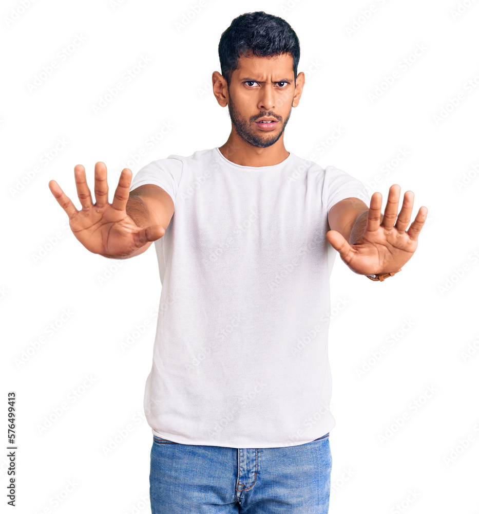 Young latin man wearing casual clothes doing stop gesture with hands palms, angry and frustration expression Young latin man wearing casual clothes doing stop gesture with hands palms, angry and frustration expression